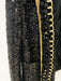 Black sequined outfit with gold zipper and decorative trim on a white background