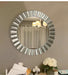 Round decorative mirror with a metallic frame on a wall.