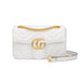 White quilted handbag with gold chain and logo on a white background