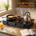 Portable stove top with cooking items on a kitchen counter, featuring a kettle, pan, and pot.