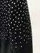 Black dress with white polka dot pattern on a beige background