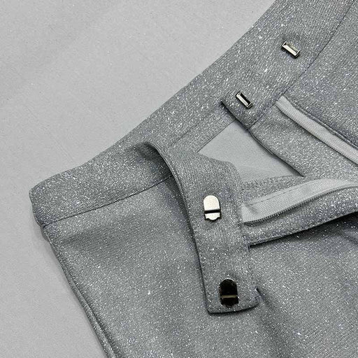 Close-up of gray pants with button details on a gray background
