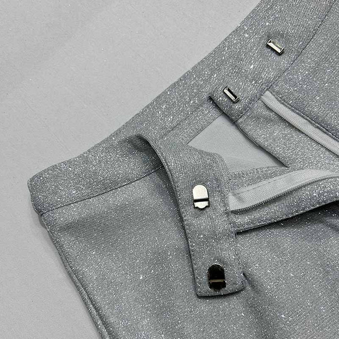 Close-up of gray pants with button details on a gray background