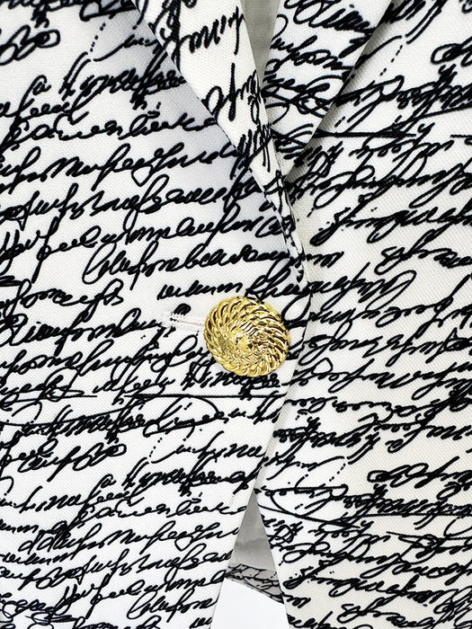White shirt with a gold button on a background of black cursive text