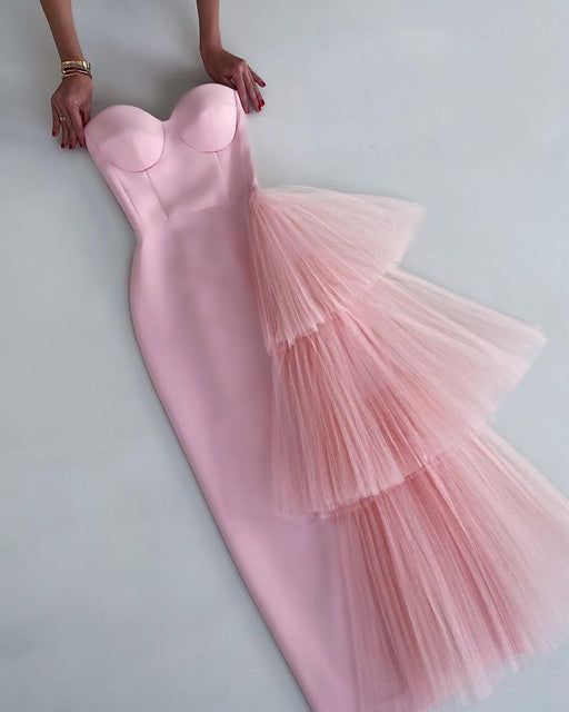 A long pink dress with a tube top and a flowing mesh skirt.