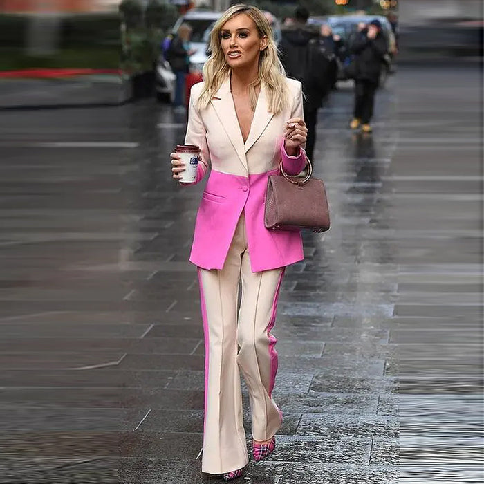 Woman in a pink and beige suit walking on a city street.