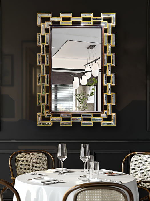 Decorative mirror with geometric frame above a set dining table in a restaurant.