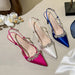 Three high-heeled shoes in pink, white, and blue with embellishments on a light surface.