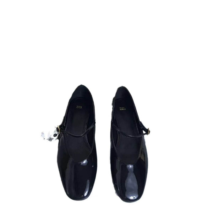 Pair of black patent leather shoes on a white background
