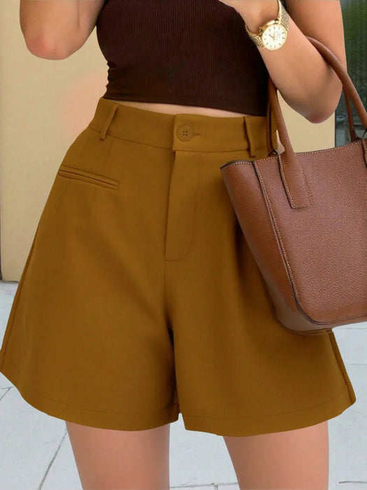 Person wearing mustard yellow shorts and a brown top, holding a matching handbag.