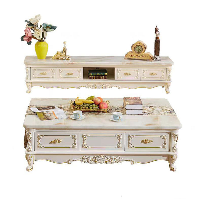 Decorative coffee table with marble top and ornate design, featuring fruits and books on a white background.