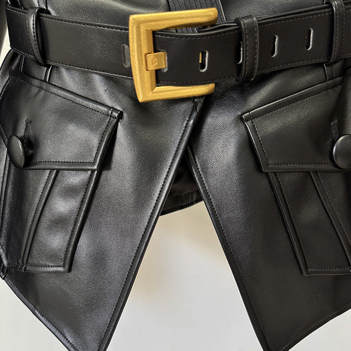 Black leather pants with a gold belt buckle on a neutral background