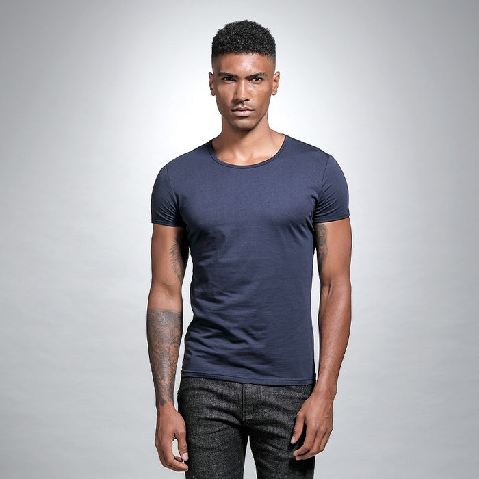 Man wearing a navy blue t-shirt against a gray background