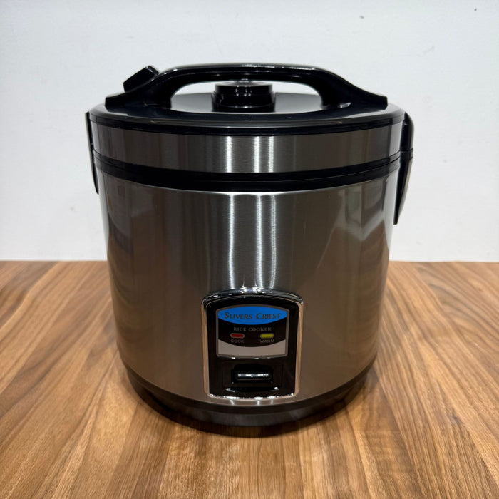 Stainless steel rice cooker on a wooden surface with a white background
