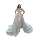 Woman wearing a white wedding gown with a long train on a white background
