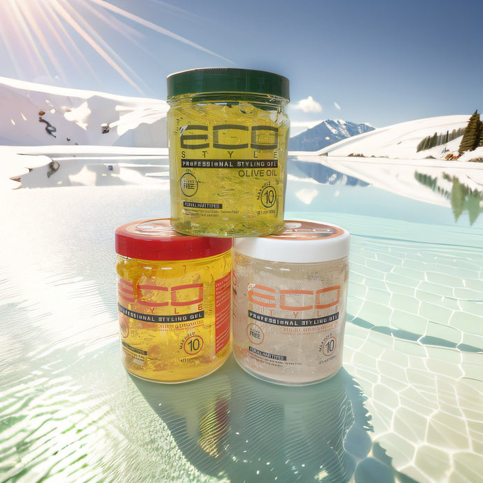 Three jars of Eco Styling Oil on a reflective surface with a snowy mountain landscape in the background
