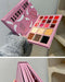 Makeup palette with 'Hot Taste' design on a pink box, held by a person wearing gray socks.