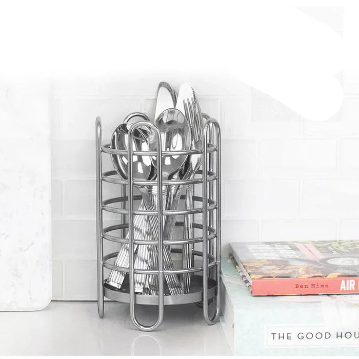 Silver utensil holder with cutlery on a white surface, featuring 'The Good House' branding.