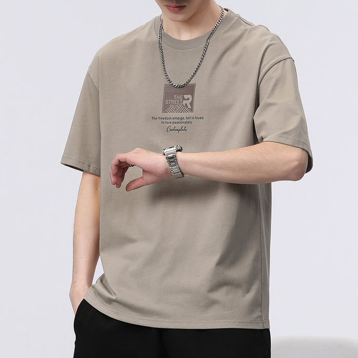 Person wearing a beige t-shirt with a logo and text on a white background