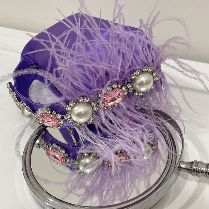 Purple handbag with decorative elements on a white background