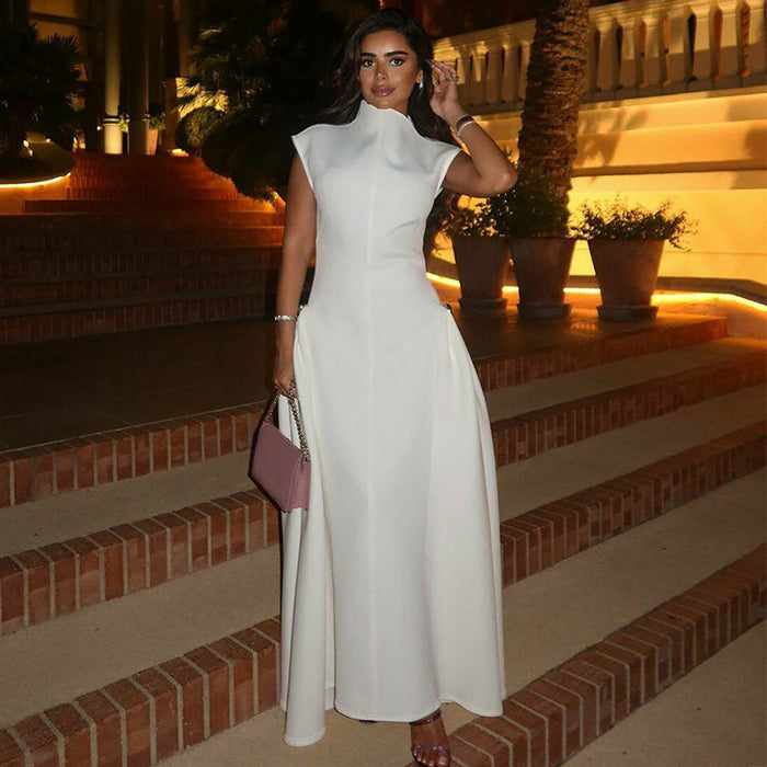 Woman in a white dress standing on steps with decorative plants and architecture in the background