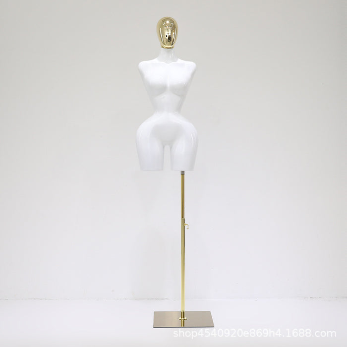 White mannequin torso on a gold stand against a white background