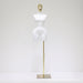White mannequin torso on a gold stand against a white background