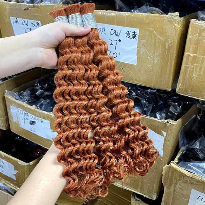 Red curly hair extensions held by a hand with cardboard boxes in the background