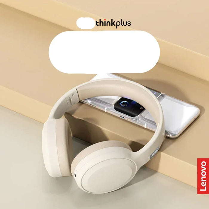 White headphones with a smartphone on a beige surface, featuring Lenovo branding.