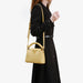 Woman holding a yellow handbag against a white background