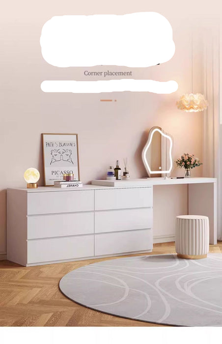Modern white dresser with mirror and decor items in a room setting.
