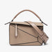 Beige handbag with a strap on a light gray background
