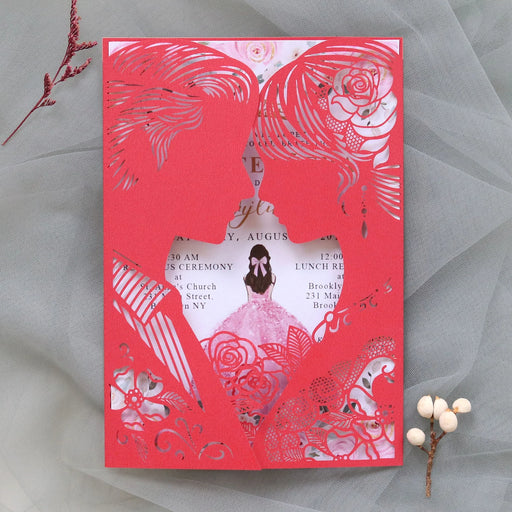 Red and white laser-cut wedding invitation with floral and butterfly design on a gray background.