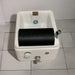 White ceramic sink with black soap holder on a tiled floor