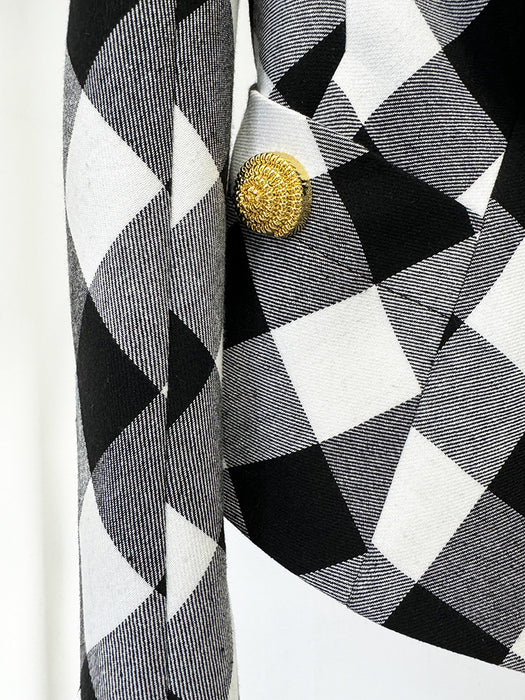 Close-up of a black and white checkered fabric with a gold button on a white background