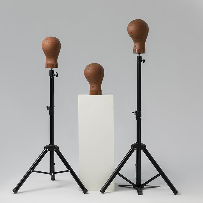 Two black stands with brown leather dummies on a gray background