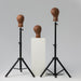 Two black stands with brown leather dummies on a gray background