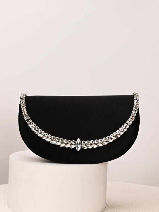 Black handbag with silver embellishments on a white pedestal against a light gray background