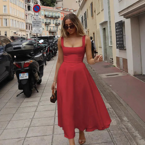 Woman in a red dress walking on a city street.
