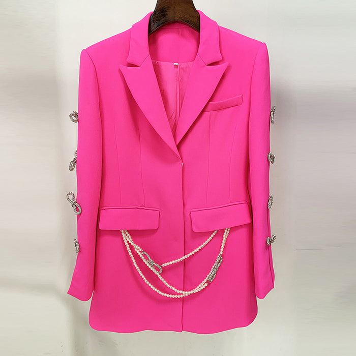 Pink blazer with decorative buttons and a chain on a white background