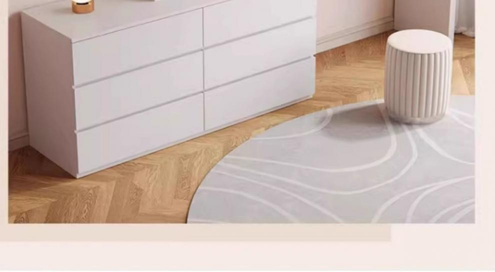 White dresser with a gray rug on a wooden floor