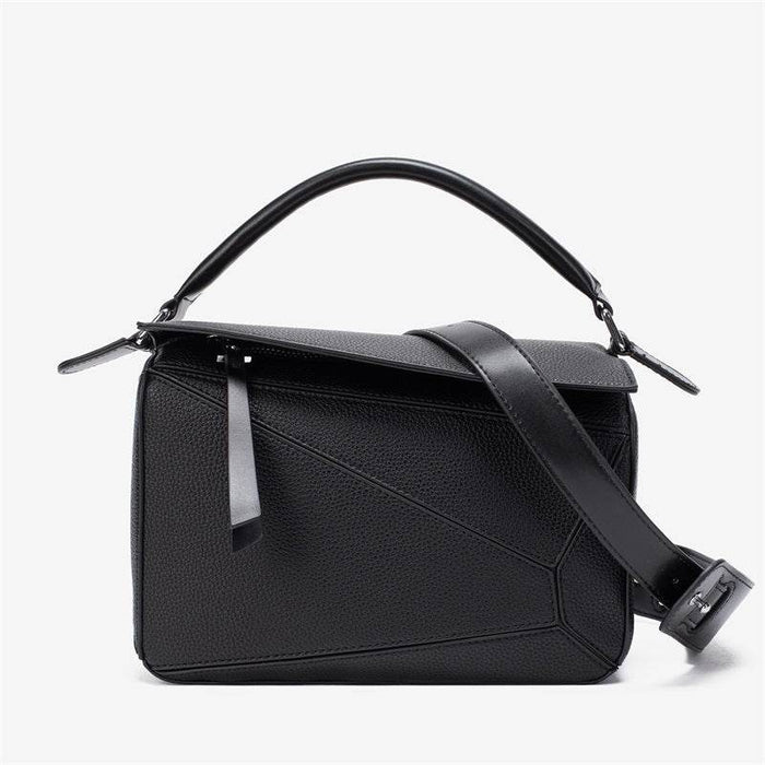 Black handbag with a strap on a white background