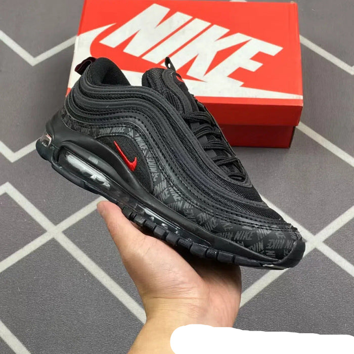 Black Nike sneaker held in a hand with a red Nike box in the background.