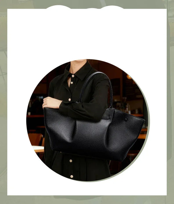 Person holding a black handbag with text on a light gray background