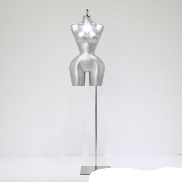 Silver mannequin torso on a stand against a white background