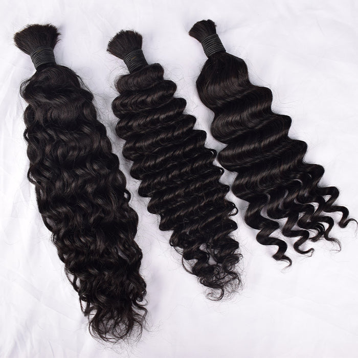 Three bundles of curly black hair extensions on a white background