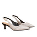 A pair of pointed-toe slingback pumps in textured light beige leather with a low kitten heel, black interior lining, and a small gold-tone ring detail on the slingback strap, shown against a plain white background.
