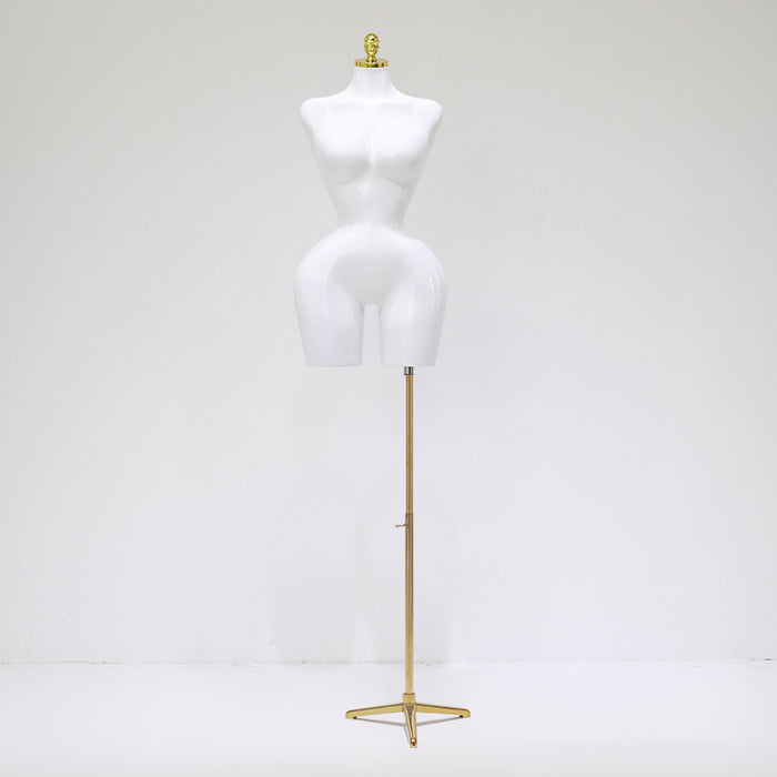 White mannequin torso on a gold stand against a white background