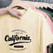 Beige t-shirt with 'California' text on a hanger with other shirts.
