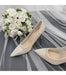 Pair of wedding shoes with a bouquet of white roses on a gray fabric background